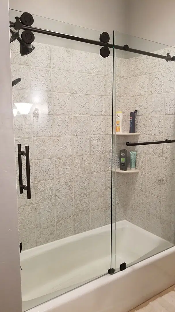 sliding shower door and glass panel over bathtub